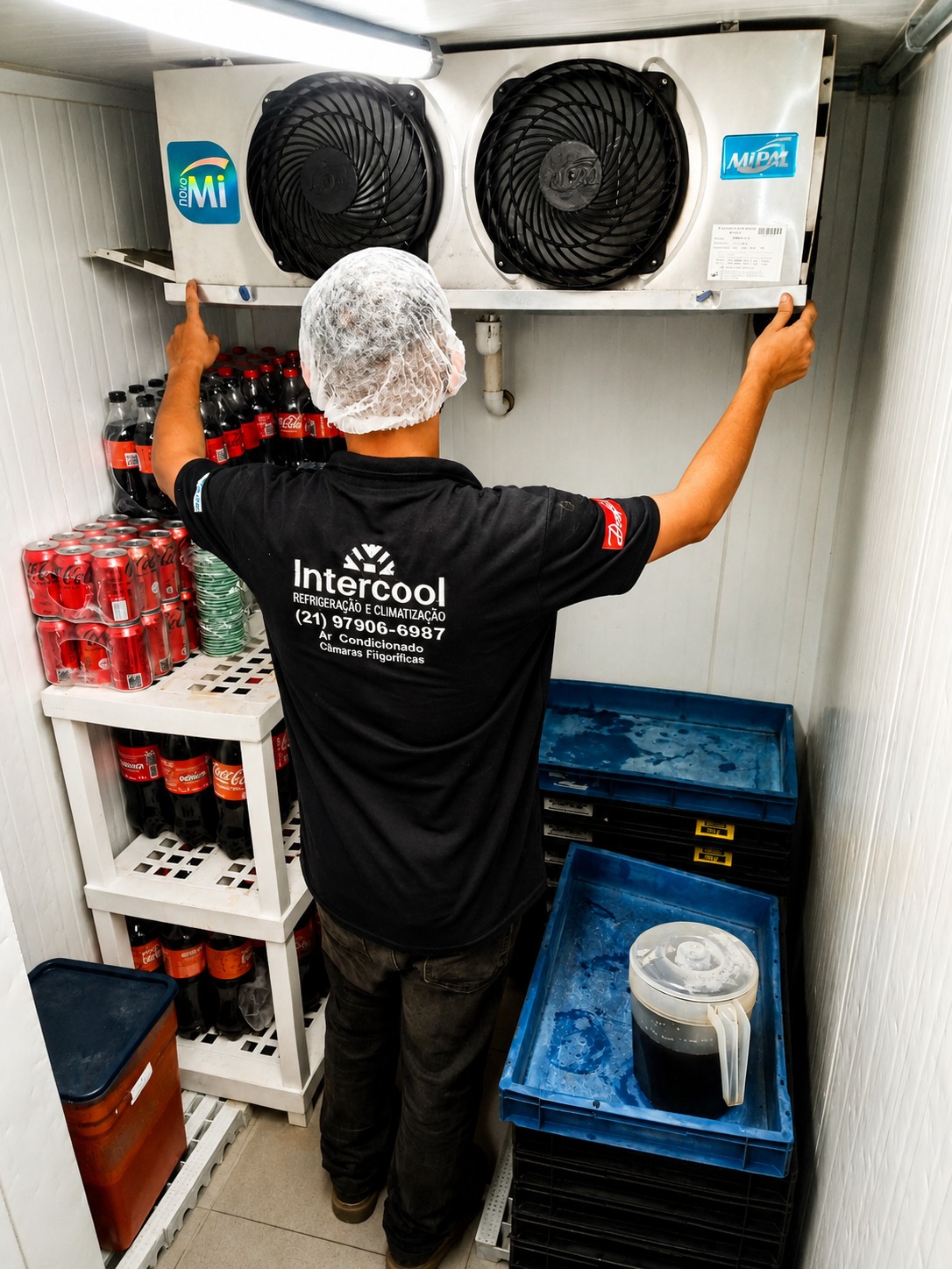 Técnico Intercool instalando evaporador em câmara fria com bebidas armazenadas